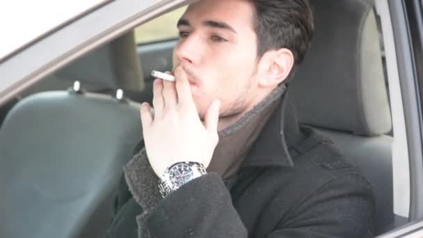 Jeune homme fumant de la cigarette en conduisant — Video