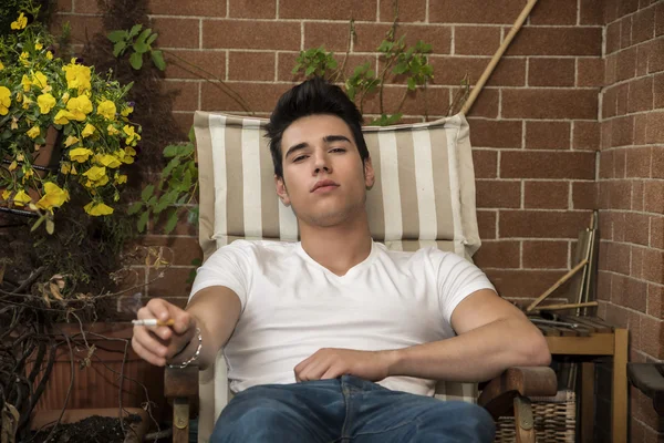 Handsome young man smoking a cigarette outside — Stock Photo, Image