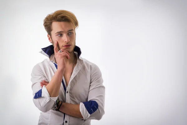 Attractive young man thinking, looking up with hand on his chin — Stock Photo, Image