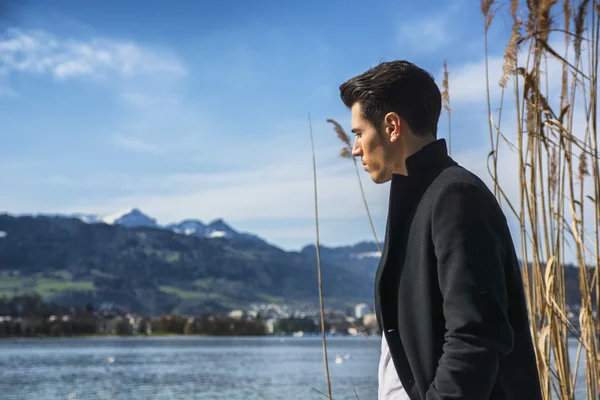 Handsome young man on Luzern lakes shore — Stock Photo, Image