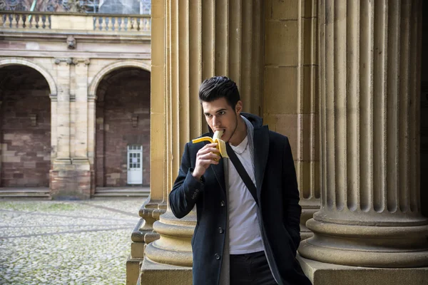 Hombre con pie de banana en la calle en Lausana mientras mira hacia abajo —  Fotos de Stock