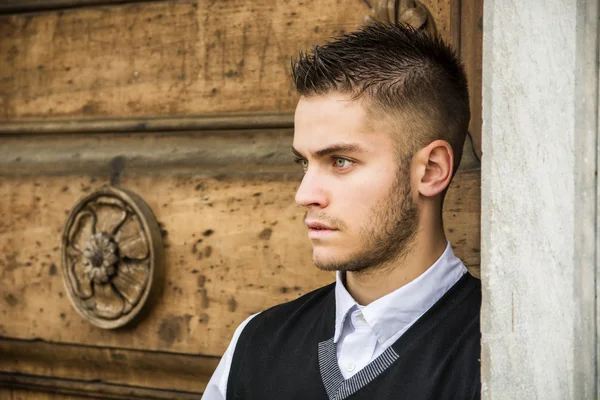 Schöner junger Mann gegen alte Holz Tür — Stockfoto