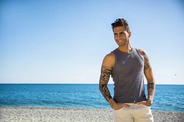 Hombre joven en la playa en el soleado día de verano — Foto de Stock