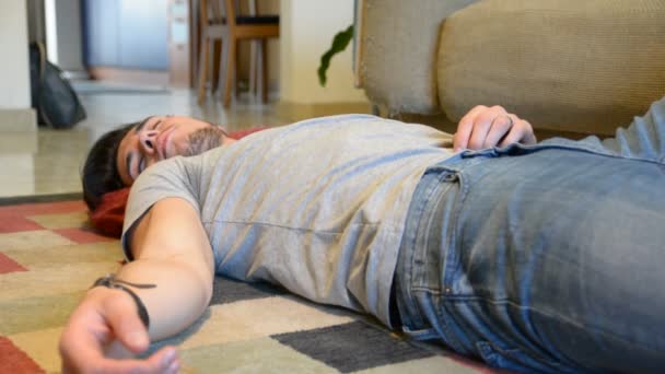Человек спит и зевает на полу — стоковое видео