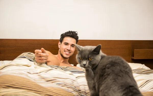 Bonito jovem abraçando seu gato cinza Pet — Fotografia de Stock