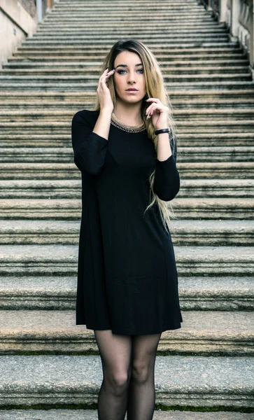 Açık havada siyah elbiseli güzel bir kadın.