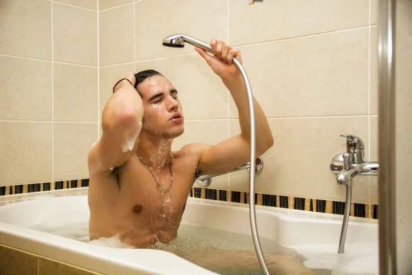 Küvette banyo yapan yakışıklı genç adam. — Stok fotoğraf