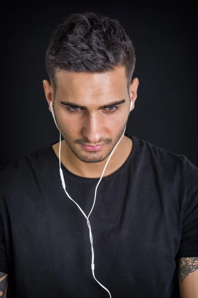 Young man with earphones listening to music — Stock Photo, Image