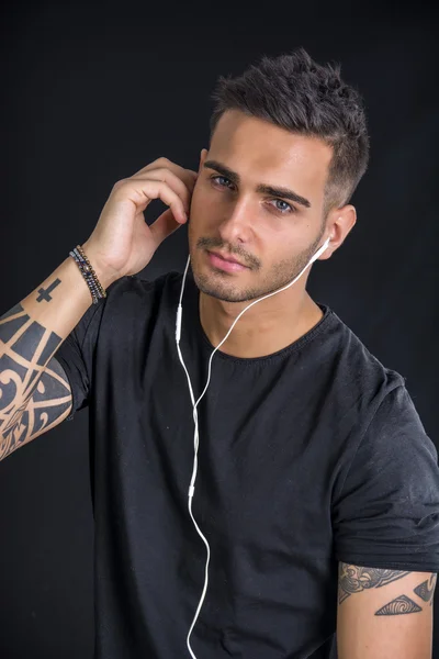 Jeune homme avec écouteurs écoutant de la musique — Photo