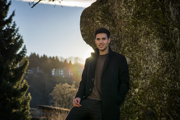 Schöner junger Mann lehnt an Baum — Stockfoto