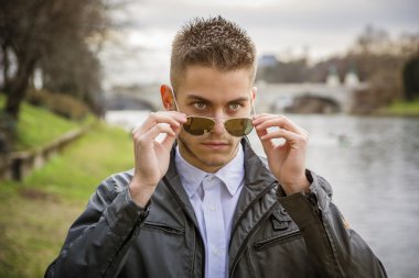 Nehir kenarında duran dalgın genç adam