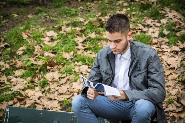 Portrait of man reading in park — Stock fotografie