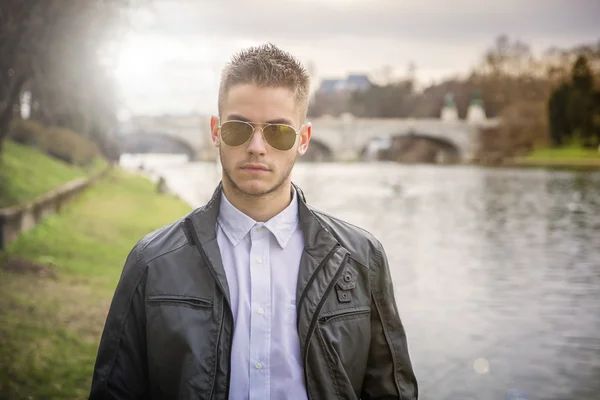 Kontemplativní mladý muž stál vedle řeky — Stock fotografie