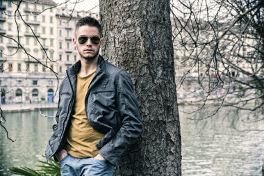 Nehir kenarında duran dalgın genç adam