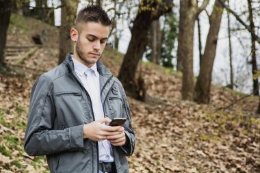 Cep telefonu kullanarak parkta genç adam