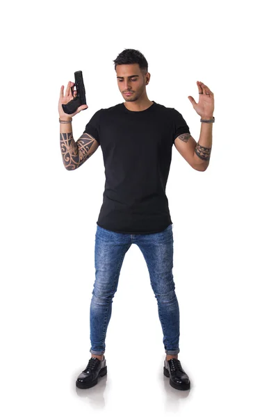 Handsome man with gun holding raised arms — Zdjęcie stockowe