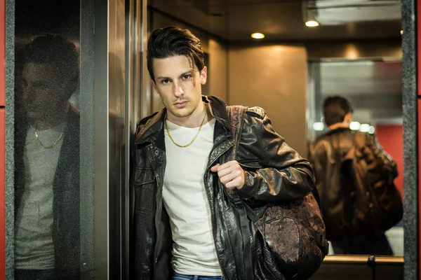 Handsome young man leaning against mirror in elevator or lift — Stock Photo, Image