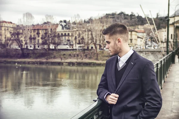 Hombre joven contemplativo de pie al lado del río —  Fotos de Stock