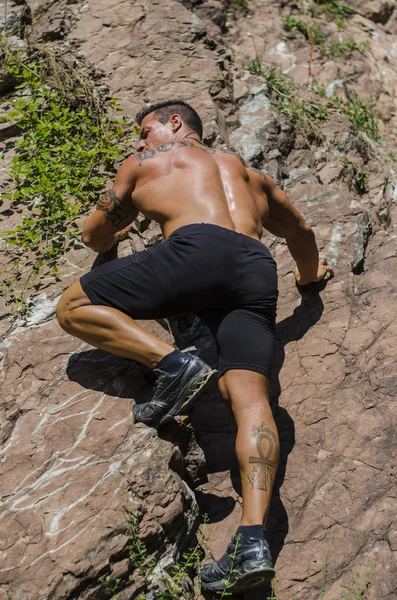 Handsome, muscular, shirless climber climbing rock — Stock Photo, Image
