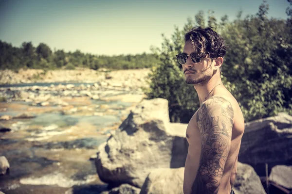 Athletic shirtless young man outdoor at river or water stream — Stock Photo, Image