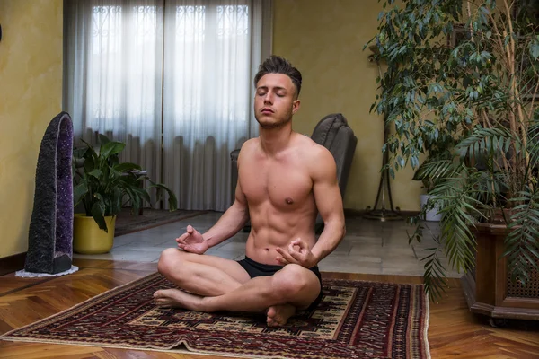 Jovem meditando em sua sala de estar chão — Fotografia de Stock