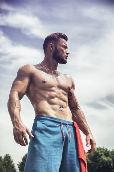 Portrait of handsome topless man with tattooed body looking away — Stockfoto