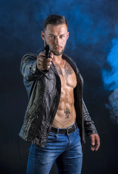 Mann richtet Waffe auf Kamera und trägt Jacke auf nacktem Oberkörper — Stockfoto