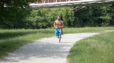 Gömleksiz kas adam yolu üzerinde koşu