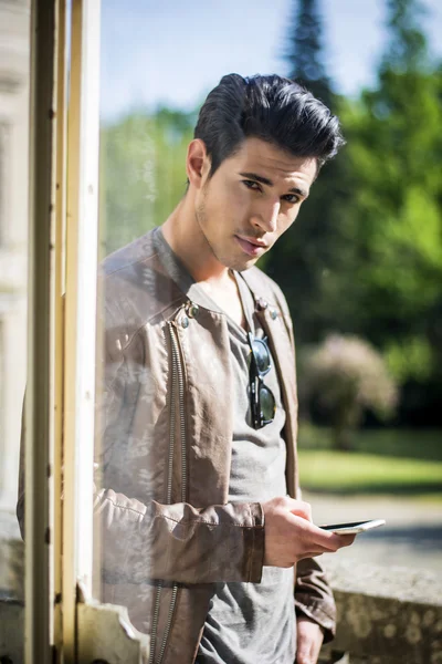 Seductive young man with cell looking at camera — Fotografia de Stock