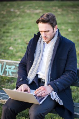 Parkta çalışan yakışıklı, zarif iş adamı.