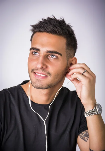 Young man with earphones listening to music — Stock Photo, Image