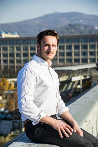 Handsome trendy man sittiing outdoor — Stock Photo, Image