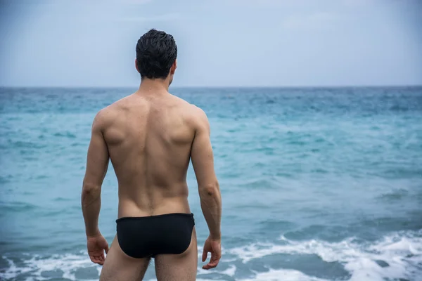 Vue arrière de l’homme dans les troncs contre de seascape — Photo