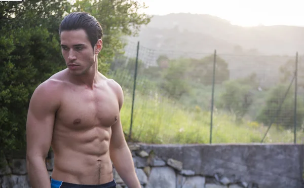 Attractive muscular shirtless young man in nature — Stock Photo, Image