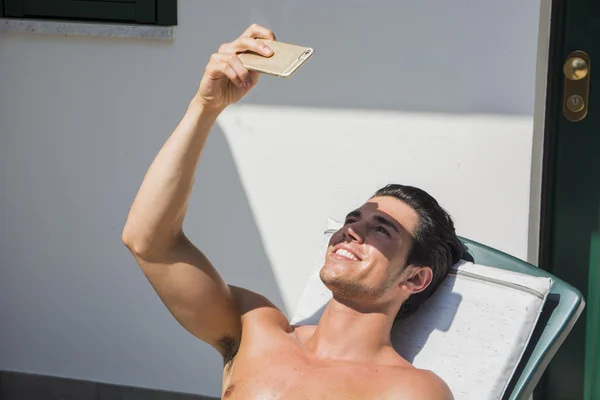 Young Man Sunbathing and Taking Selfie picture — Stock Photo, Image