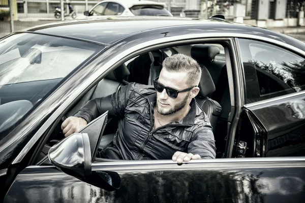 Handsome skäggig man går ur bil i solglasögon — Stockfoto