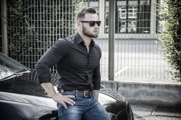 Handsome bearded man next to car in sunglasses — Stock Photo, Image
