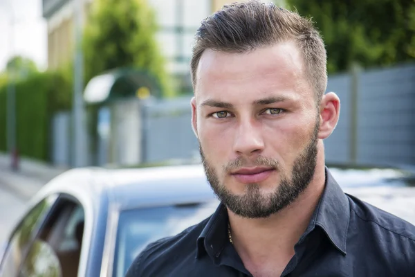 Headshot of handsome bearded man next to car — Stockfoto