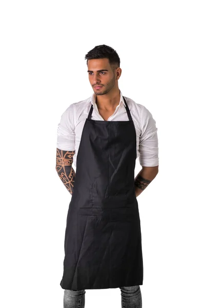Joven chef o camarero con delantal negro aislado — Foto de Stock