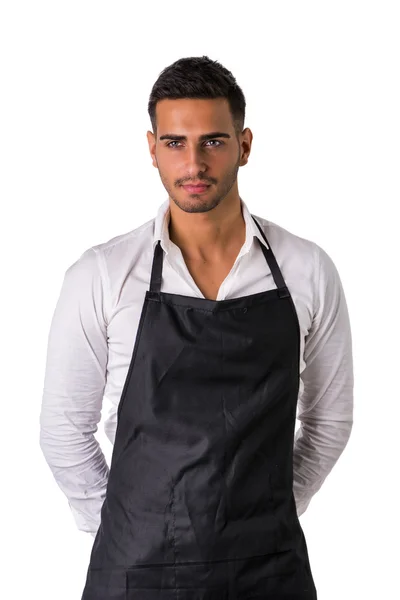 Jonge chef-kok of ober draagt zwarte schort geïsoleerd — Stockfoto