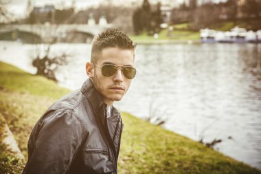 Nehir kenarında oturan düşünceli genç adam