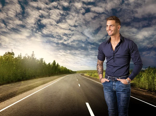 Young smiling man in blue shirt and jeans isolated — Stock Photo, Image