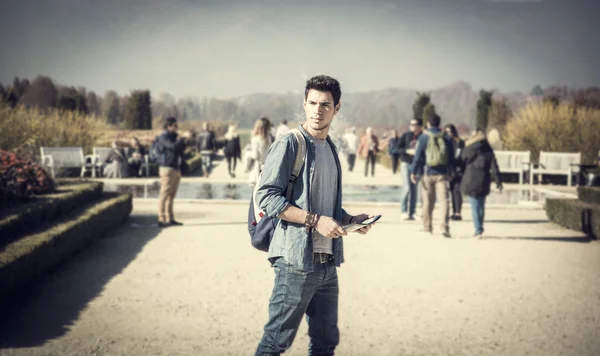 Handsome young man sightseeing in a park — Stock Photo, Image