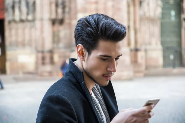 Mladý muž v použití mobilní venkovní v Evropě — Stock fotografie