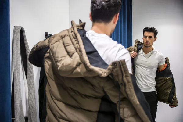 Hombre joven probándose la ropa en la tienda de ropa —  Fotos de Stock