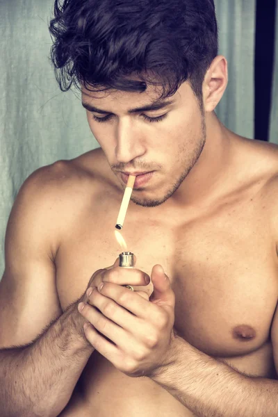 Jeune homme musclé torse nu fumant une cigarette — Photo