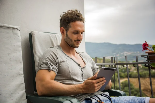 Handsome trendy man looking down at a tablet computer, outdoor — Stock Photo, Image