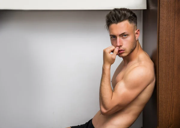 Sexy jonge man shirtless zit in zijn kamer — Stockfoto