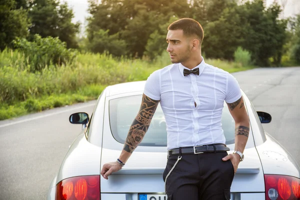 Przystojny młody mężczyzna obok samochodu w białej koszuli — Zdjęcie stockowe