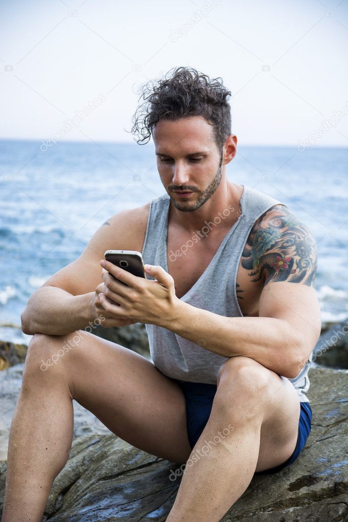 man at the seaside using cell phone